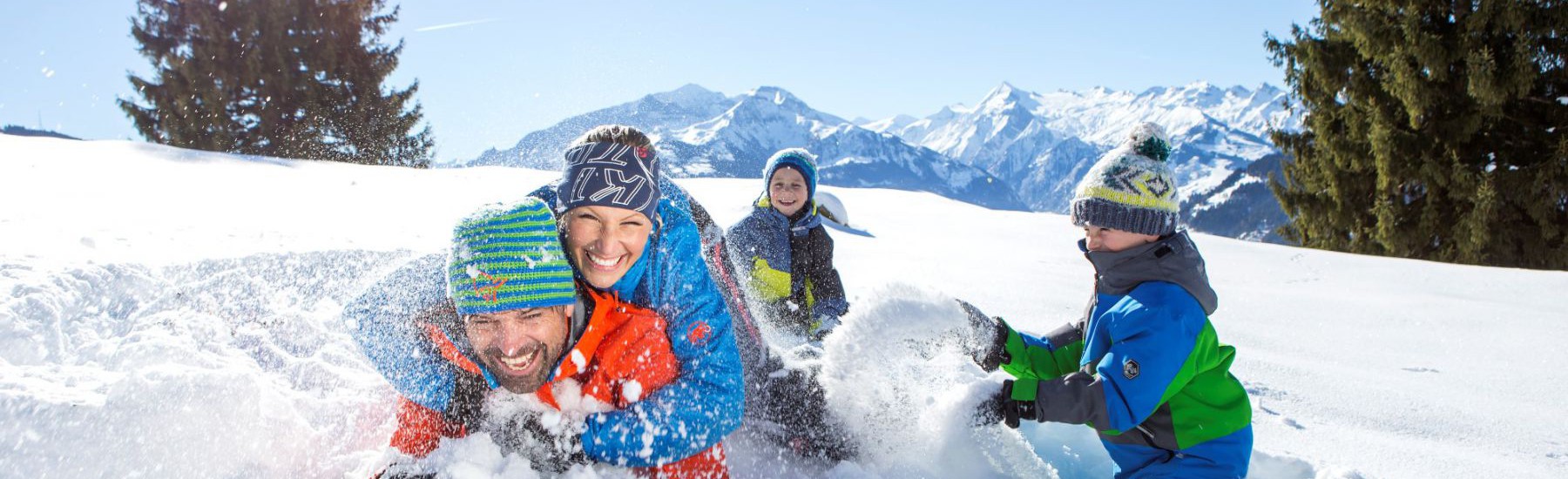 familie speelt met sneeuw in zell am see